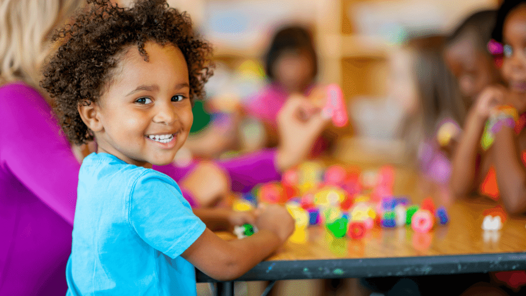 Young Child playing with blocks and smiling